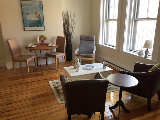 sitting room featuring baseboard heating and hardwood / wood-style flooring