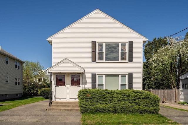 traditional-style home with fence and entry steps