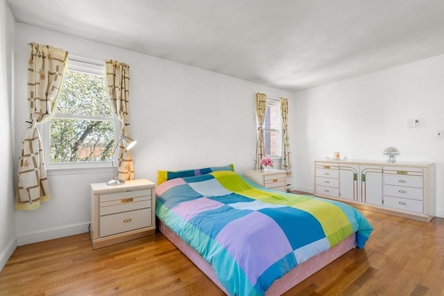 bedroom featuring light wood-style flooring and baseboards