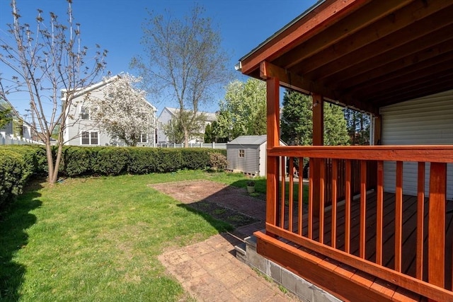 view of green lawn featuring a shed, a deck, and an outdoor structure