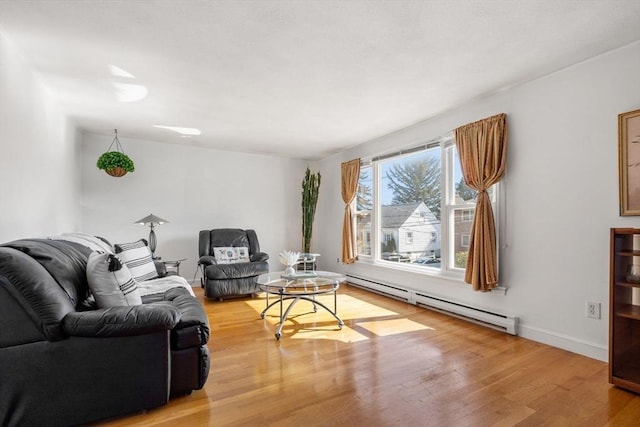 living area featuring baseboard heating, light wood finished floors, and baseboards
