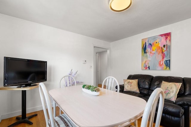 dining space with wood finished floors and baseboards