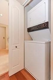 200 Falls Blvd Unit F305, Quincy, MA 02169 - washroom featuring stacked washing machine and dryer and wood finished floors