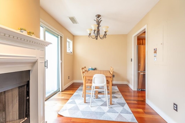 200 Falls Blvd Unit F305, Quincy, MA 02169 - dining area with light wood-type flooring, a chandelier, baseboards, and a fireplace with flush hearth