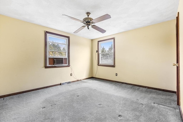 carpeted empty room featuring visible vents, plenty of natural light, a ceiling fan, and baseboards