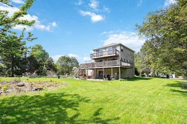 rear view of house featuring a wooden deck, a yard, and stairway