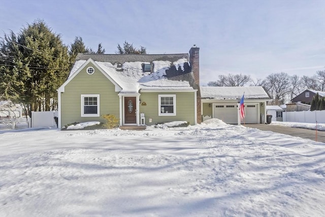 view of front of property with driveway, a chimney, an attached garage, and fence