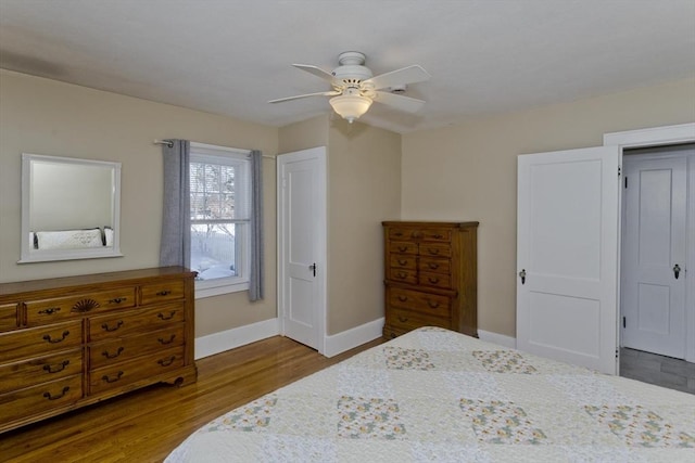 bedroom with wood finished floors, a ceiling fan, and baseboards