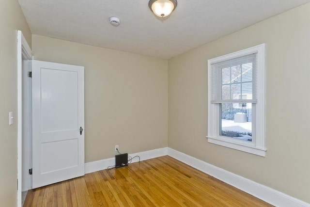 empty room with light wood-style flooring and baseboards