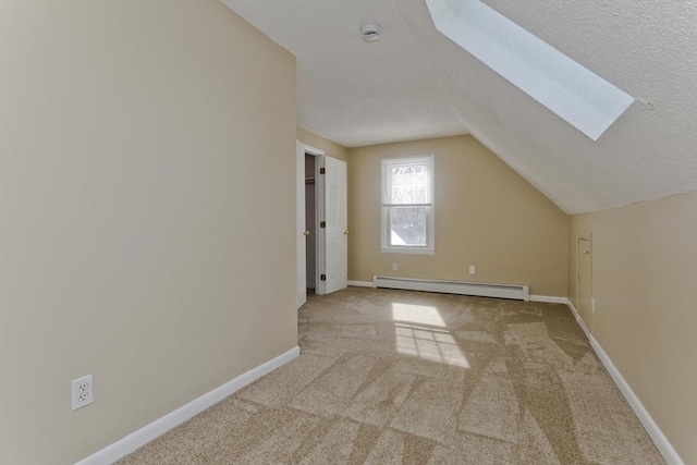 bonus room with carpet floors, vaulted ceiling with skylight, baseboards, and baseboard heating