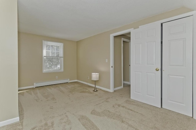 unfurnished bedroom featuring carpet floors, a baseboard radiator, and baseboards