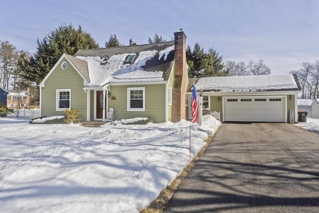 view of front of home featuring driveway, an attached garage, and a chimney