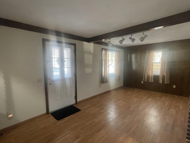 foyer featuring wood-type flooring and beam ceiling