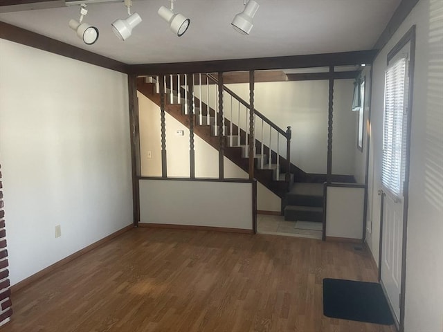 basement with wood-type flooring and rail lighting