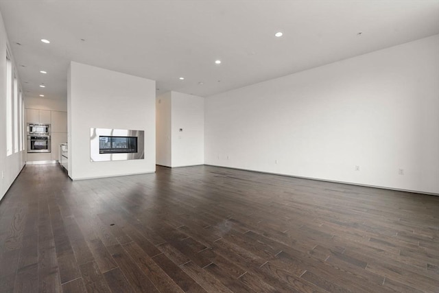 unfurnished living room with dark hardwood / wood-style flooring