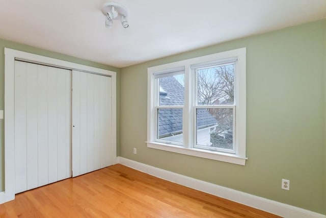 unfurnished bedroom with hardwood / wood-style flooring and a closet