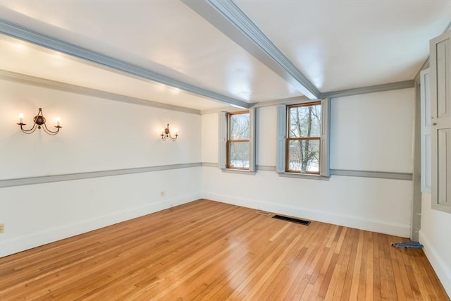 unfurnished room with hardwood / wood-style flooring and beam ceiling