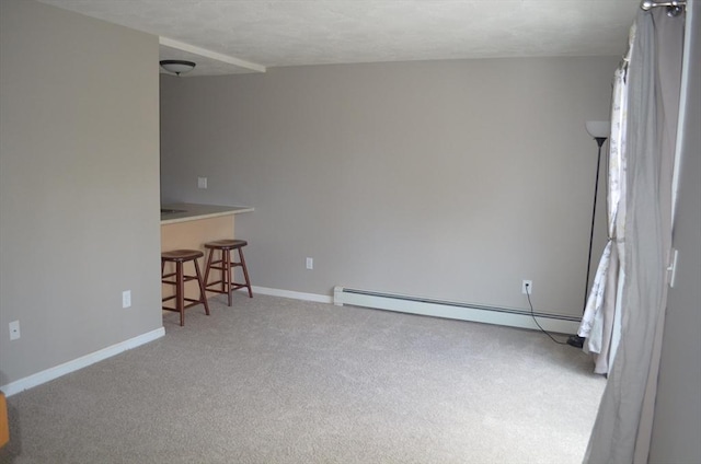 carpeted empty room featuring a textured ceiling, a baseboard heating unit, and baseboards