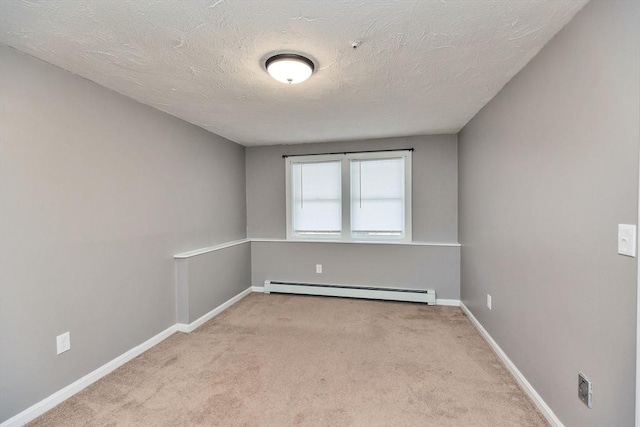 carpeted spare room featuring baseboards, baseboard heating, and a textured ceiling