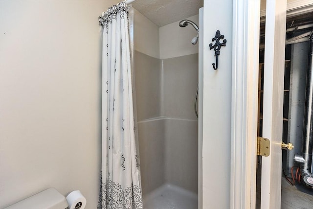 full bathroom with a shower stall and toilet