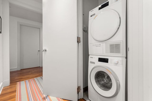washroom with light wood finished floors, laundry area, and stacked washer and clothes dryer