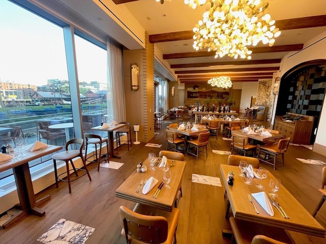interior space featuring beamed ceiling, a chandelier, and wood finished floors
