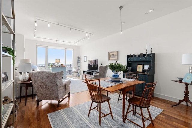 dining area featuring track lighting and wood finished floors