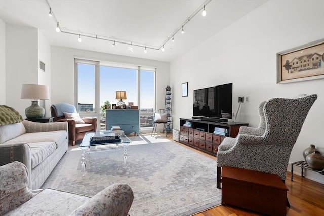 living area featuring track lighting, wood finished floors, and visible vents