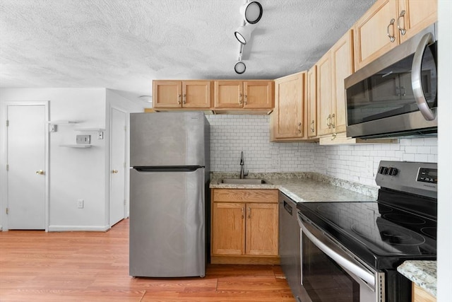 108 Oak Ln Unit 3, Brockton, MA 02301 - kitchen featuring stainless steel appliances, a sink, a textured ceiling, light wood finished floors, and tasteful backsplash