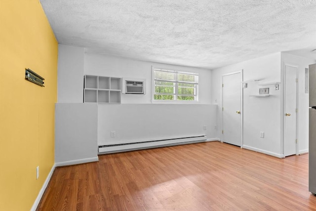 108 Oak Ln Unit 3, Brockton, MA 02301 - unfurnished room featuring a baseboard heating unit, a textured ceiling, wood finished floors, baseboards, and an AC wall unit