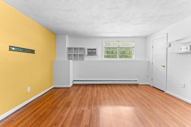 108 Oak Ln Unit 3, Brockton, MA 02301 - empty room with baseboard heating, wood finished floors, a textured ceiling, a wall mounted AC, and baseboards