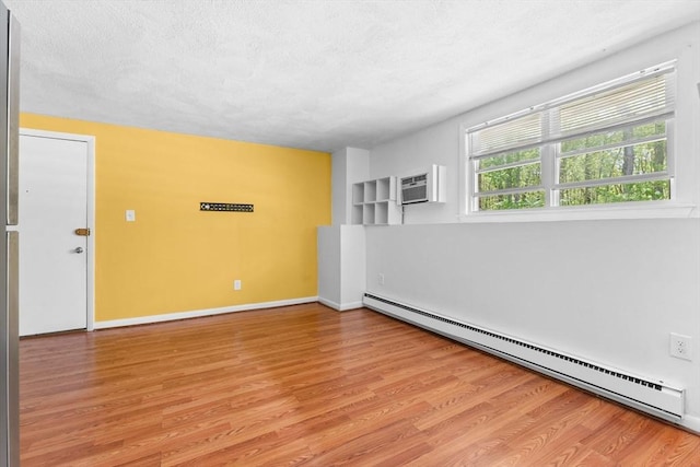 108 Oak Ln Unit 3, Brockton, MA 02301 - spare room featuring a baseboard radiator, light wood-type flooring, a textured ceiling, an AC wall unit, and baseboards