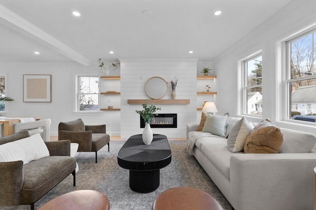 living area featuring baseboards, recessed lighting, ornamental molding, beamed ceiling, and a large fireplace