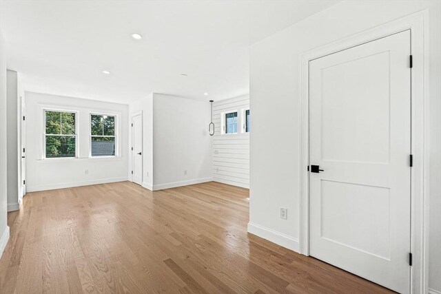 unfurnished room with recessed lighting, baseboards, plenty of natural light, and light wood finished floors