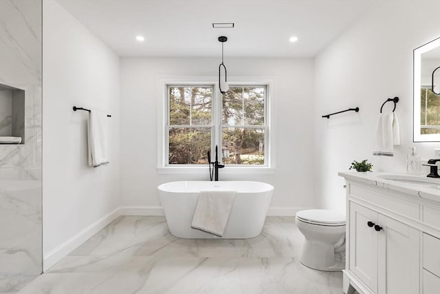 bathroom featuring baseboards, a freestanding bath, recessed lighting, marble finish floor, and vanity