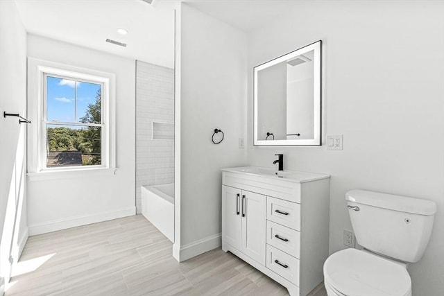 bathroom with visible vents, toilet, vanity, and baseboards