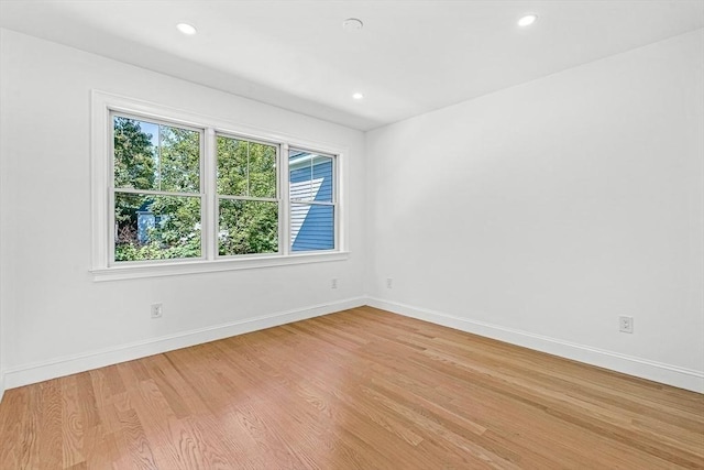 empty room featuring light wood-style flooring, recessed lighting, and baseboards