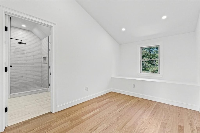 spare room featuring vaulted ceiling, recessed lighting, baseboards, and light wood finished floors