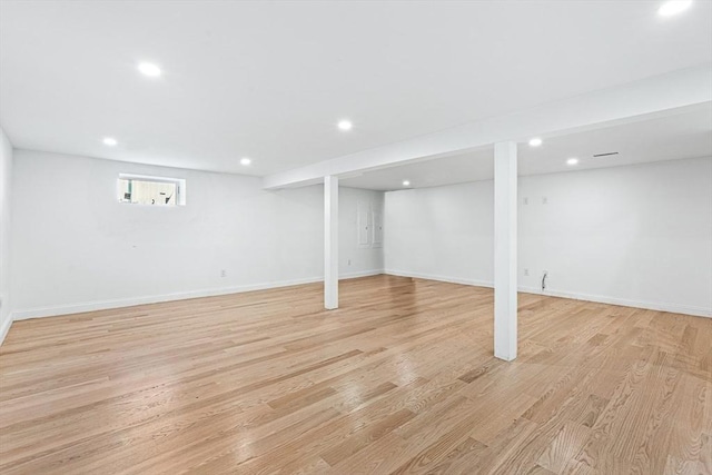 below grade area with recessed lighting, light wood-style flooring, and baseboards