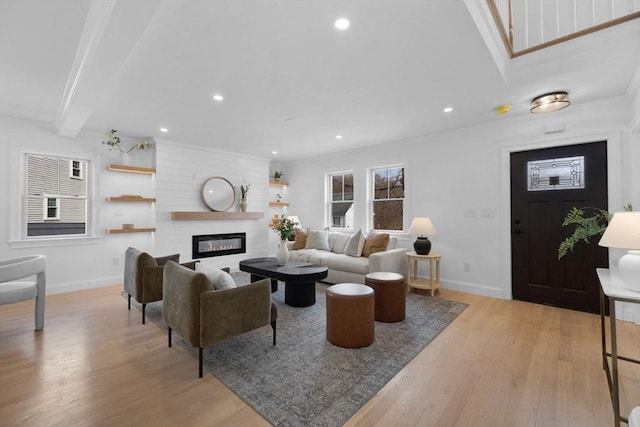 living area with recessed lighting, light wood-style flooring, a large fireplace, and baseboards