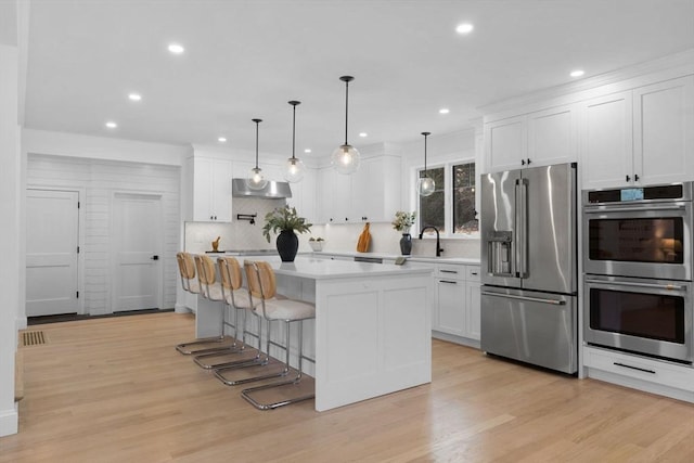 kitchen featuring white cabinetry, stainless steel appliances, light countertops, and extractor fan