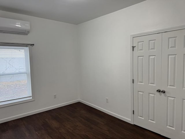 empty room with dark hardwood / wood-style floors, a healthy amount of sunlight, and a wall unit AC