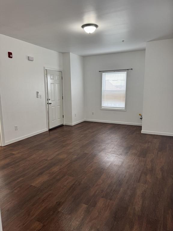 empty room with dark hardwood / wood-style floors