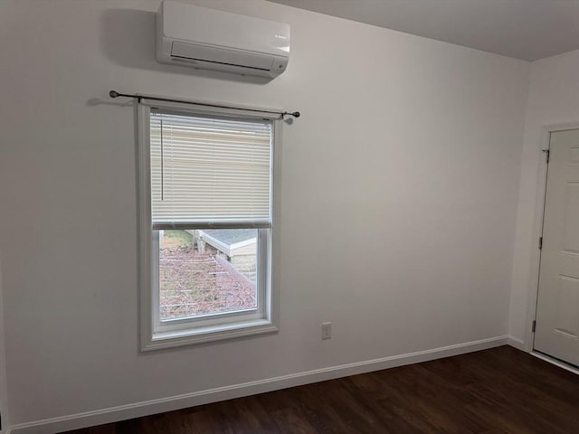 spare room with dark hardwood / wood-style flooring and a wall unit AC