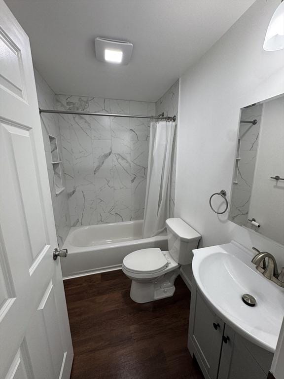 full bathroom featuring hardwood / wood-style flooring, vanity, shower / bath combination with curtain, and toilet