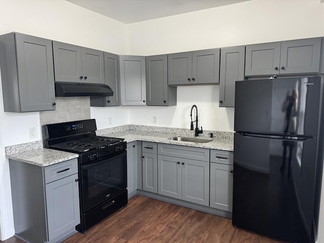 kitchen featuring black gas range, fridge, gray cabinetry, and sink