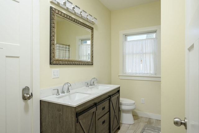 bathroom with vanity, toilet, and wood-type flooring