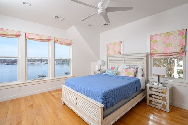 bedroom featuring a water view, ceiling fan, and wood-type flooring