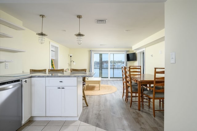 kitchen with dishwasher, a breakfast bar, pendant lighting, light wood-type flooring, and white cabinets