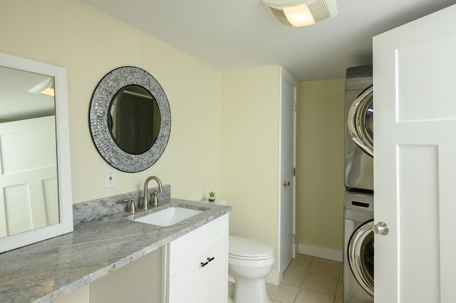 bathroom with vanity, stacked washer / drying machine, toilet, and tile patterned flooring